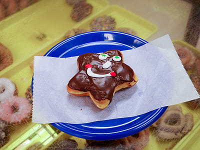 A smiley faced star donut sitting on a blue plate thumbnail