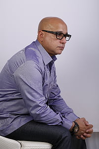 man in purple dress shirt sitting on chair thumbnail