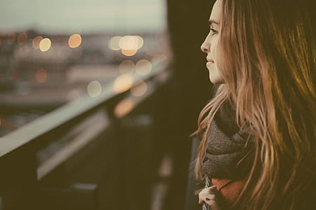 long blonde-haired woman in black top standing thumbnail