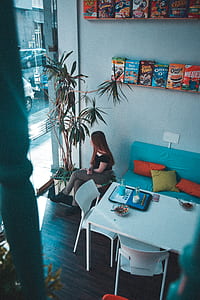 woman sitting beside blue couch thumbnail