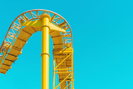 yellow metal roller coaster track under blue sky at daytime thumbnail