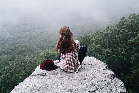 woman sitting on edge of rock cliff thumbnail