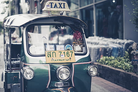green auto rickshaw parked near wall thumbnail