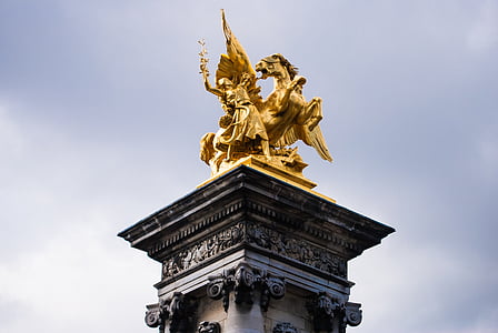 gold-colored horse with wings and woman statue thumbnail