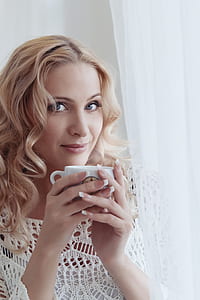 woman holding white ceramic mug thumbnail
