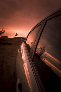 car parked near tree during sunset thumbnail