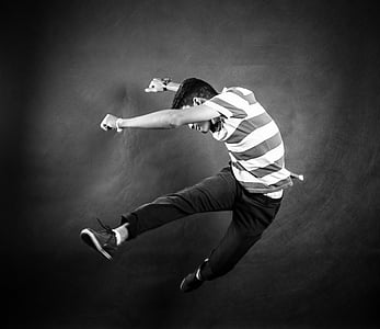 smiling man jumping while raising both hands thumbnail