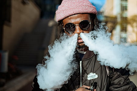 man doing dragon trick with vape during daytime thumbnail
