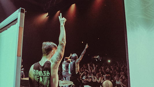 man raising hands on stage thumbnail