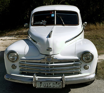 classic white vehicle parked near trees thumbnail