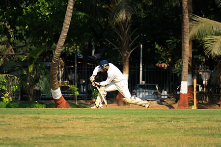 man swinging bat on green grass field during daytime thumbnail