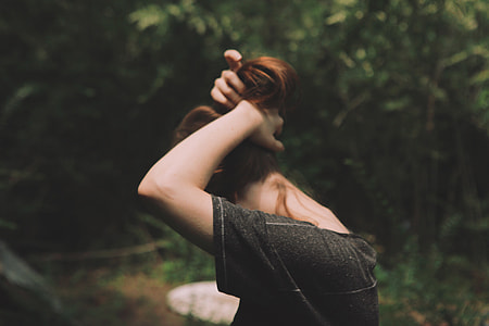 standing woman tying her hair at daytime thumbnail