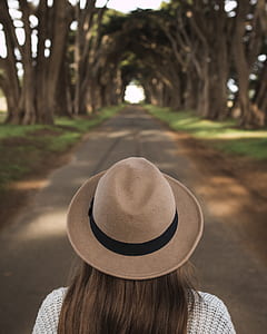 woman waling on pathway surrounded with trees thumbnail