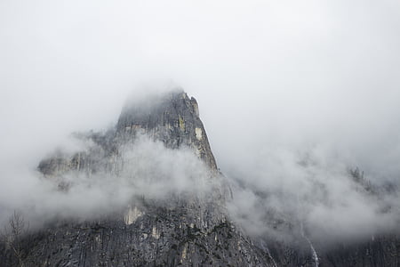gray rock mountain covered with fog thumbnail