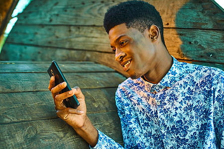 man wearing white and blue dress shirt holding black smartphone thumbnail