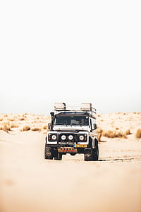 white SUV travelling on dirt road during daytime thumbnail