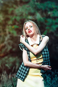 woman in yellow collared dress wearing black and white checkered vest taking a pose during daytime thumbnail