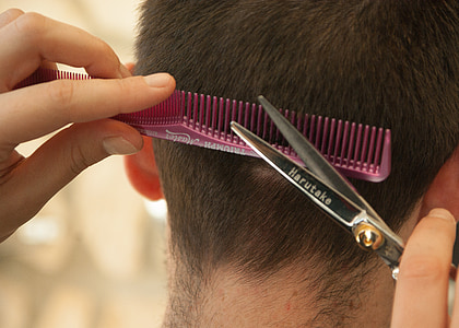 person cutting person's hair using scissors and comb thumbnail