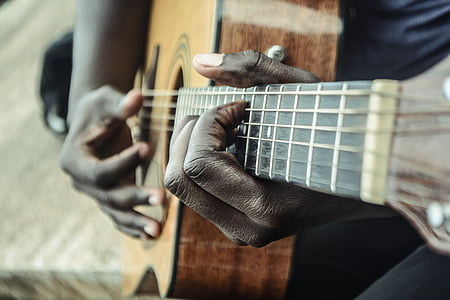 person holding brown and black dreadnought acoustic guitar thumbnail