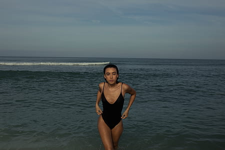 woman walking in shore during daytime thumbnail