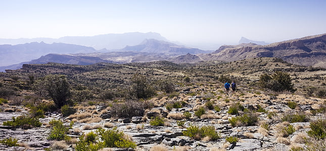 selective focus photography of two people walking on dirt road during daytimne thumbnail