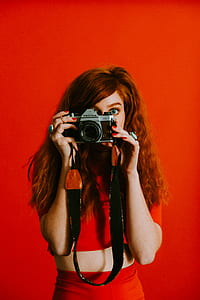 woman holding black and gray Pentax point-and-shoot camera thumbnail