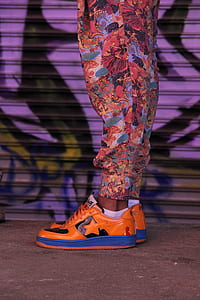 person wearing orange-and-blue low-top sneakers thumbnail