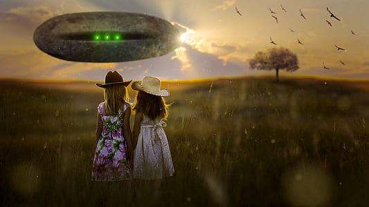 two girl's wearing dresses standing on brown grass during golden hour thumbnail