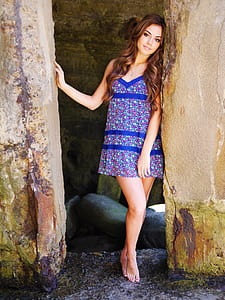 woman wearing blue dress near stone post thumbnail