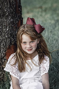 girl sitting beside brown tree thumbnail