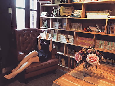 woman wearing black mini dress reading a book at the library thumbnail