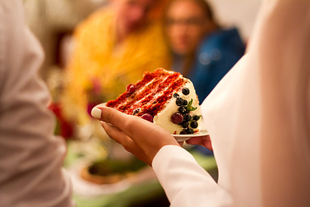 selective focus photo of person holding plate with sliced cake thumbnail