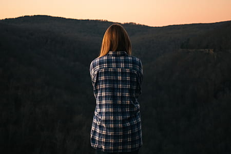 Woman Wearing Blue and White Plaid Dress Shirt in Front of Green Mountain thumbnail