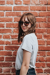 woman wearing black club master sunglasses standing behind concrete wall thumbnail