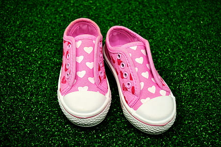pair of pink-and-white flat shoes on green grass thumbnail
