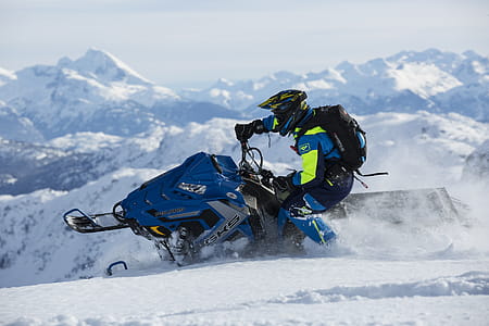 Man In Blue And Green Long-sleeved Suit Riding On Snowmobile thumbnail