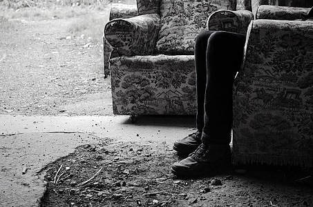 grayscale photo of person sitting on floral armchair thumbnail
