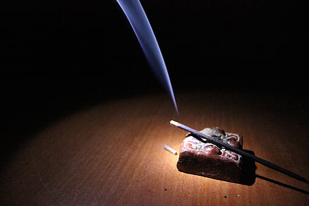 lighted black Chinese candlestick on brown surface thumbnail