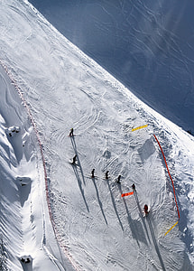 group of people skiing on snow near body of water during daytime thumbnail