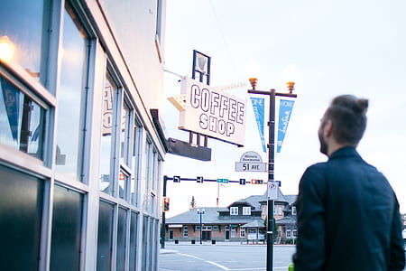 man standing in front of coffee shop thumbnail