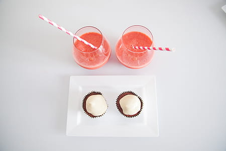 two clear drinking glasses with straws thumbnail