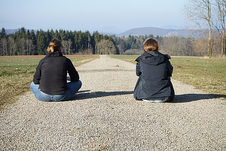 two people sitting on road during daytime thumbnail