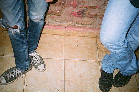 Two Person Wearing Blue Jeans and Lace-up Shoes thumbnail