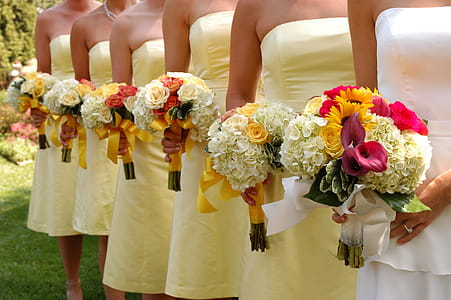 Women Wears White and Yellow Tube Strapless Dresses Holding White, Red, and Yellow Bouquet thumbnail