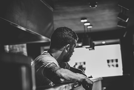 grey scale photo of man staring outside the window thumbnail