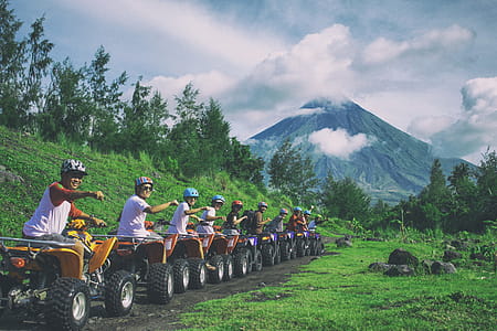 Line Of Men Riding On All Terrain Vehicles Holding Out Hand In A Fist thumbnail