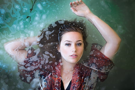 woman in maroon and gray top floating in water thumbnail