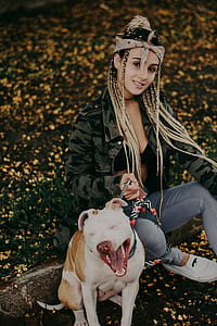 woman in gray camo jacket holding adult American pit bull terrier thumbnail