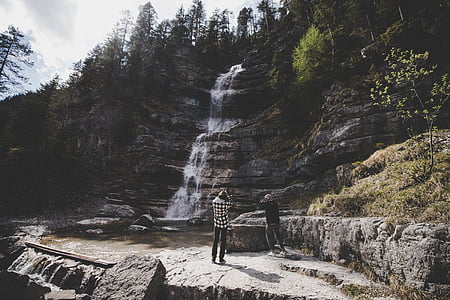 two men taking photo of waterfalls thumbnail