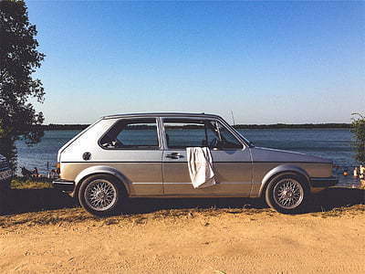 gray 5-door hatchback parked near lake thumbnail